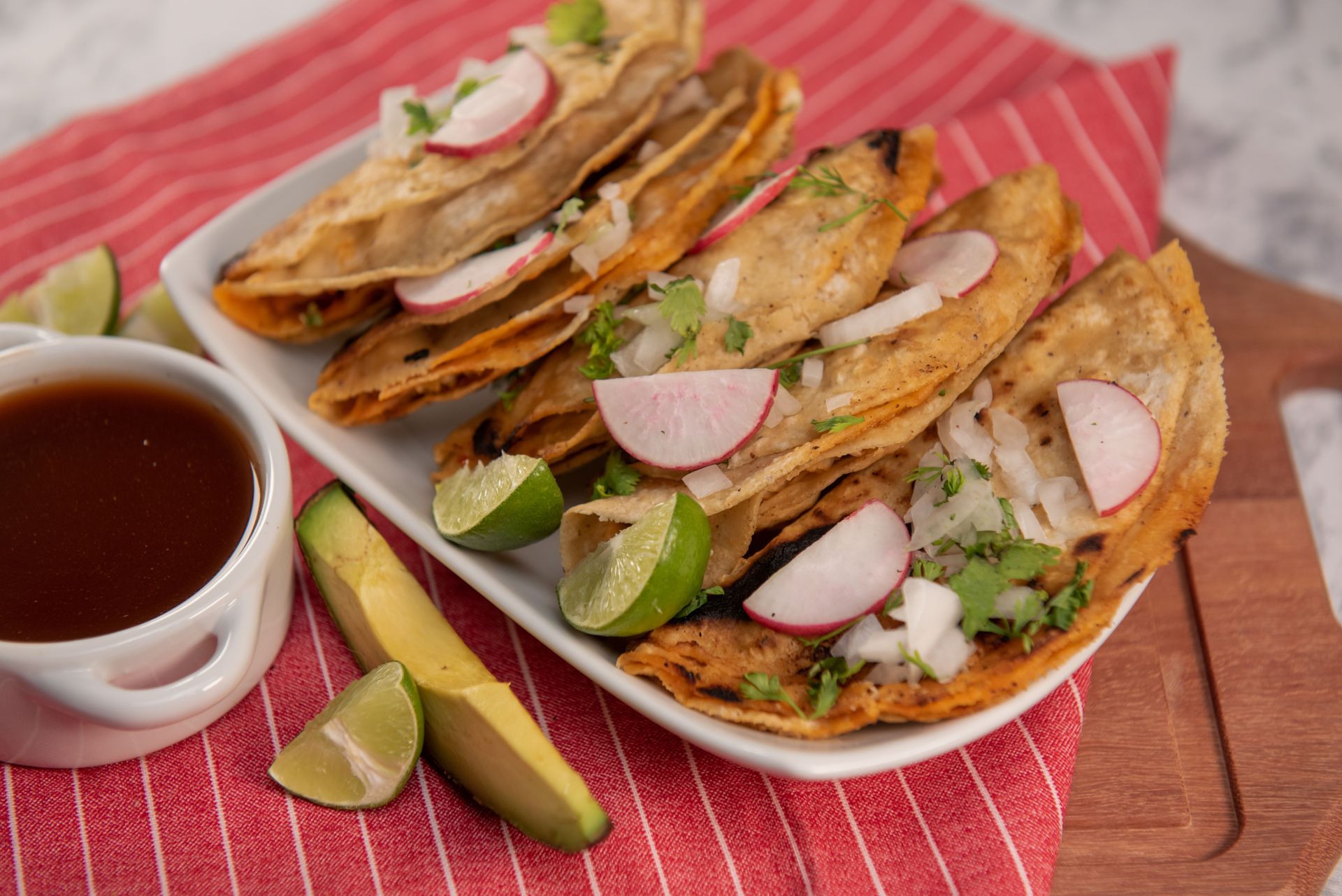 A delicious serving of traditional Mexican tacos topped with radish and onion.