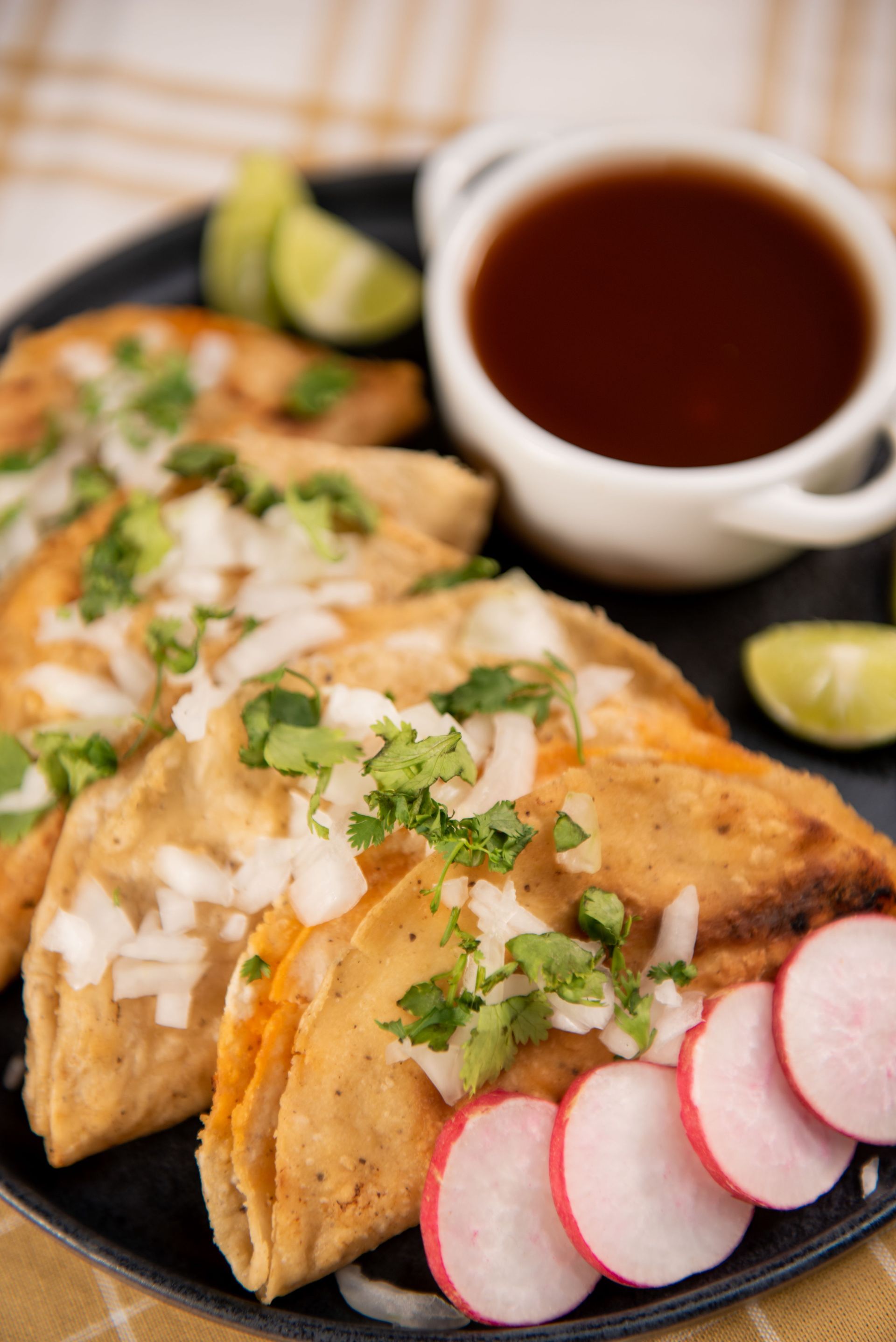 Delicious traditional Mexican tacos garnished with cilantro and onion served with fresh salsa.
