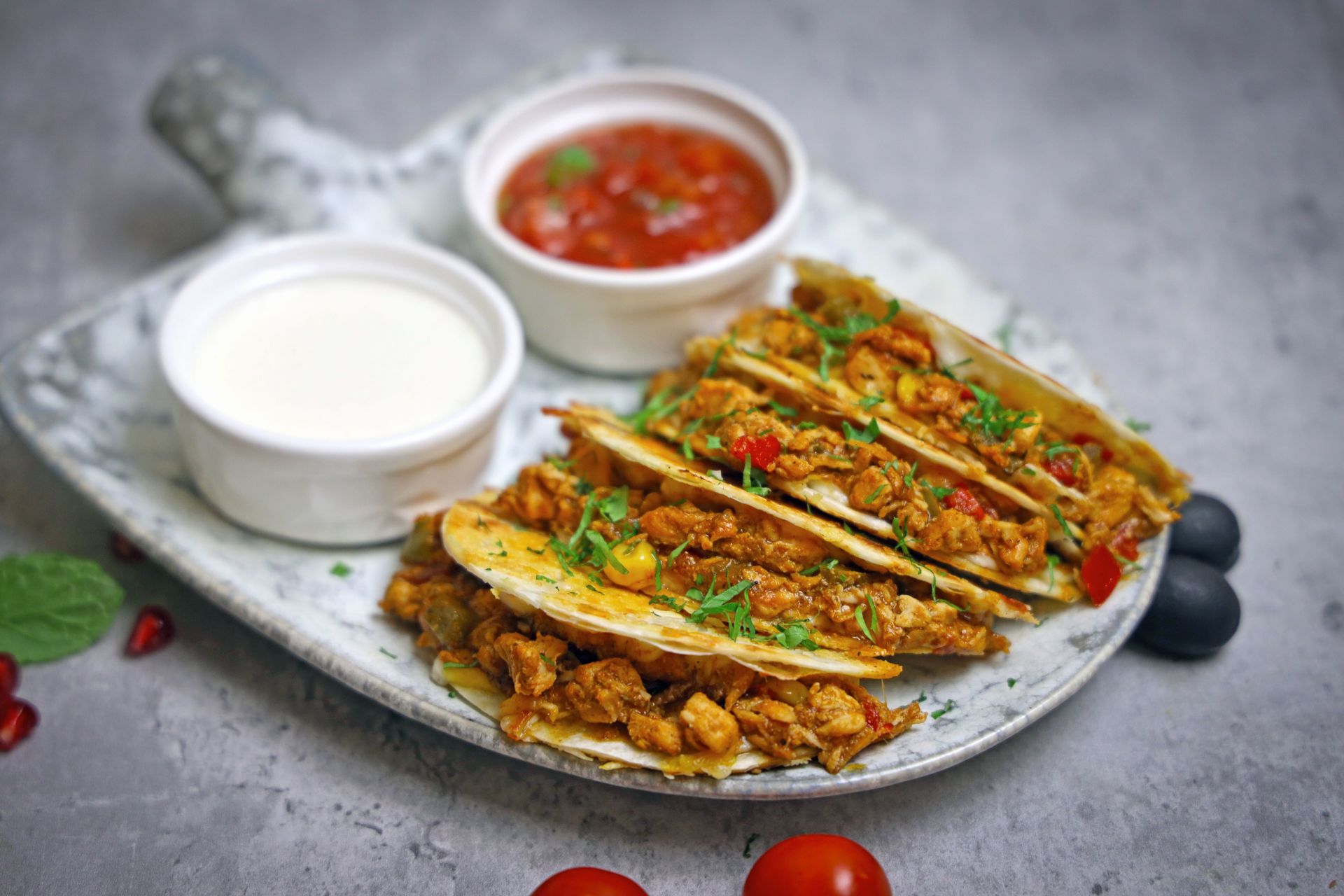 Appetizing tacos served with salsa and sour cream on a rustic plate.