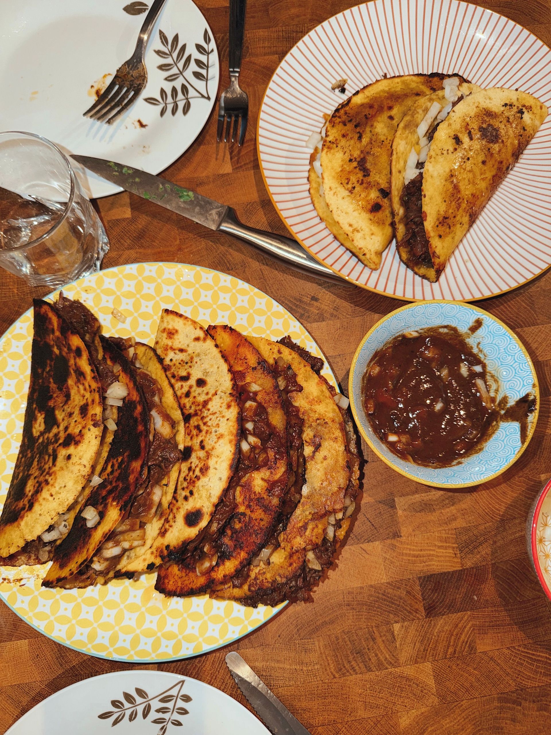 A mouth-watering display of homemade tacos served with salsa on a wooden table.